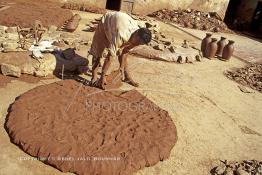 Image du Maroc Professionnelle de  Un ouvrier prend une parts d’argile pétrit, destinée au tourneur cette partie d’argile brut imprégnée d’eau se transformera en une forme d’objet grâce au savoir faire des artisans dans les ateliers de la Colline des Potiers à Safi, Vendredi 29 Août 1997. (Photo / Abdeljalil Bounhar) 